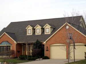 A large brick house with three dormers and garage.
