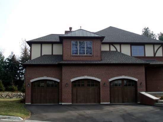 A three car garage with a large brick building.
