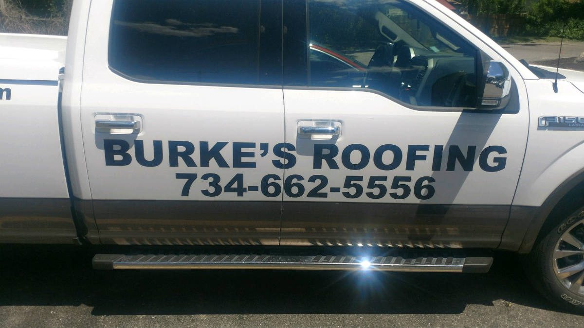 A white truck with the name burke 's roofing on it.