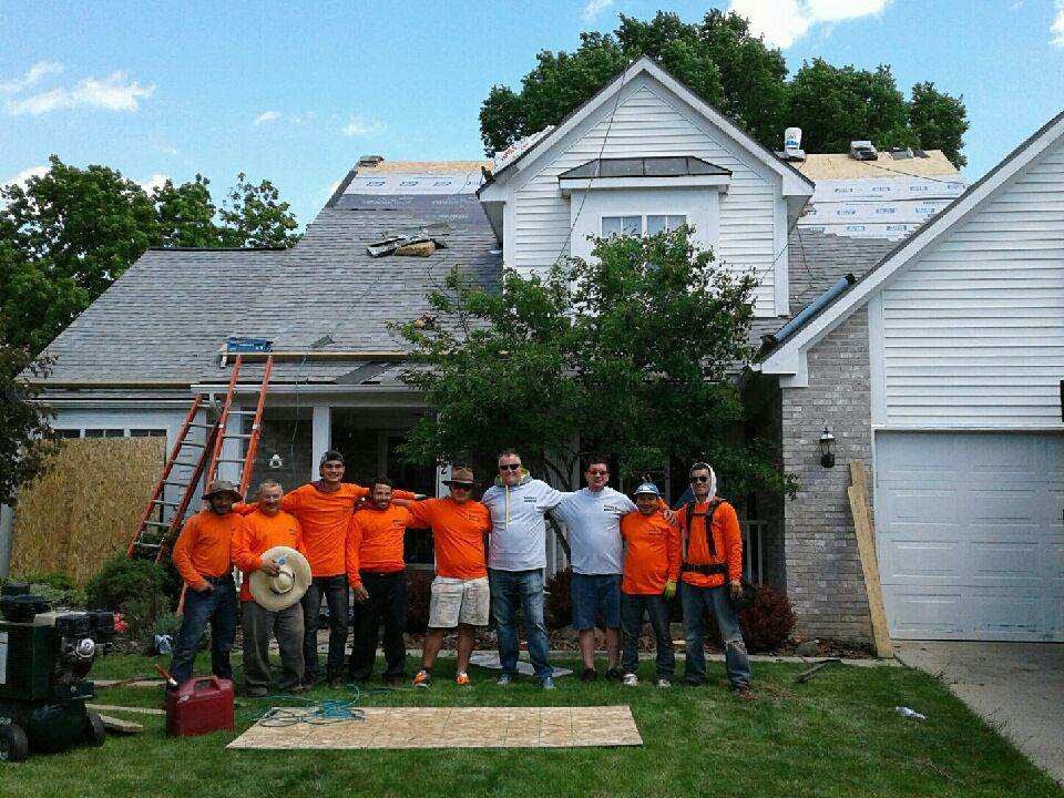 A group of men standing in front of a house.