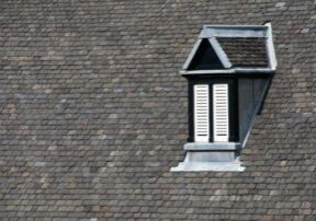 Dormer window on shingled roof.